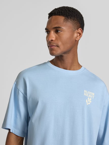 Männermodel trägt Relaxed Fit T-Shirt mit Statement-Print Modell 'RUDE' von Casual Friday in Hellblau, reine Baumwolle, Nahaufnahme Oberkörper.