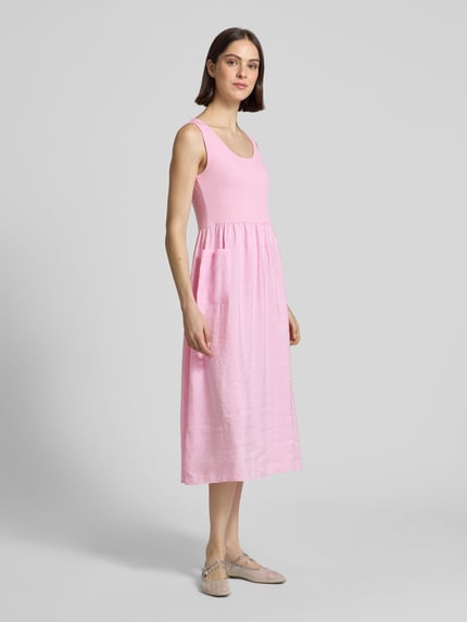 Frauenmodel trägt Midikleid aus Modal-Mix mit aufgesetzten Taschen von Rich & Royal in Rosa, A-Linie, 2-in-1-Look, Ganzkörperansicht von vorne.