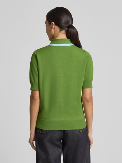 Frauenmodel trägt Regular Fit Poloshirt aus Viskose-Mix Modell 'JONDA' von Essentiel Antwerp, Optik: Unifarben, Kontraststreifen, Polokragen mit Schleife, Kurzarm, Ärmelabschluss und Rumpfabschluss gerippt, Materialverarbeitung: Taschen, Rückansicht Ganzkörperansicht.