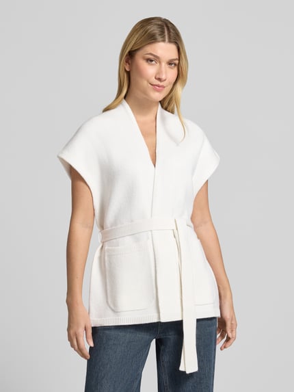Frauenmodel trägt Regular Fit Strickjacke aus reiner Schurwolle von Max Mara 'FAVILLA', mit Bindegürtel und Taschen, Weiß, Kurzarm, Ganzkörperansicht von vorne.