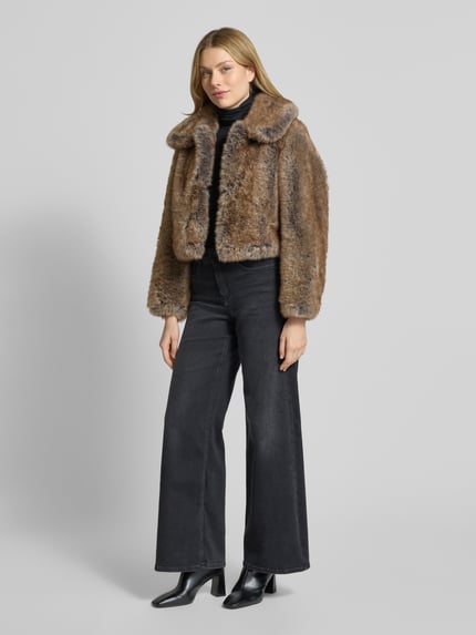 Frauenmodel trägt Jacke aus Kunstfell mit Umlegekragen Modell 'BOLA' von Mango in Braun, Regular Fit, glatte Textur, Ganzkörperansicht von vorne, Rückenlänge 47 cm, Schulterbreite 37 cm, Brustweite 54 cm, Ärmellänge 57 cm, Größe S.