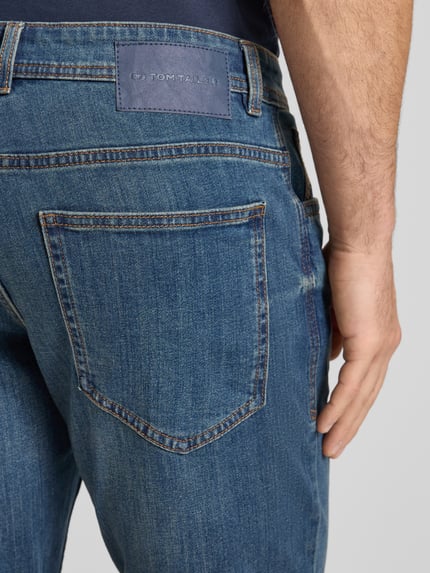 Männermodel trägt Regular Fit Jeans Bermudas aus Baumwoll-Mix von Tom Tailor in Denim-Optik mit Label-Patch, Detailaufnahme Rückansicht.