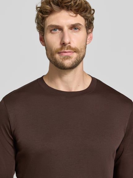 Männermodel trägt Regular Fit Longsleeve aus reiner Baumwolle Modell 'Pima' von RAGMAN in Braun, Nahaufnahme Oberkörper.