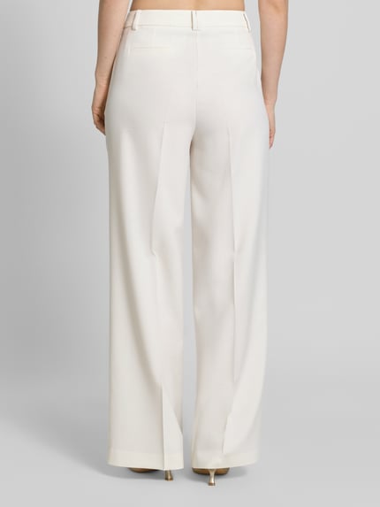 Frauenmodel trägt Stoffhose aus Viskose-Mix mit Bügelfalte von More & More in Creme, Wide-Leg-Fit, Reißverschluss, Ganzkörperansicht Rückansicht.