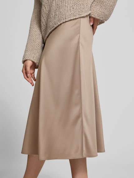 Kobiece modelka nosi spódnica midi z satyny od Juvia w kolorze beżowym, lekka linia a, elastyczny pas, długość midi, imitacja satyny, całkowita długość w rozmiarze S: 81 cm, Szerokość w rozmiarze S: 39 cm, detaliczne ujęcie z przodu.