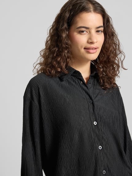 Frauenmodel trägt Relaxed Fit Bluse mit Strukturmuster von REVIEW, Schwarz, Material-Mix mit Stretch-Anteil, Hemdblusenkragen, Knopfleiste, Nahaufnahme Oberkörper.