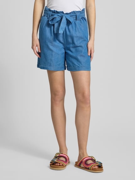 Vrouwenmodel draagt Relaxed Fit Jeansshorts uit mix van katoen en lyocell model 'BEA SMILLA' van Only, denimlook, steekzakken, strikceintuur; mix van katoen en lyocell, boord elastisch, pijpboord met omslag, kleur lichtblauw, detailopname onderlichaam, voorkant.