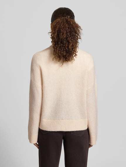 Frauenmodel trägt Regular Fit Strickjacke aus Woll-Mix Modell 'SIA' von Selected Femme, helle Farbe, strukturierte Oberfläche, Damen Strickjacke, Ganzkörperansicht Rückansicht.