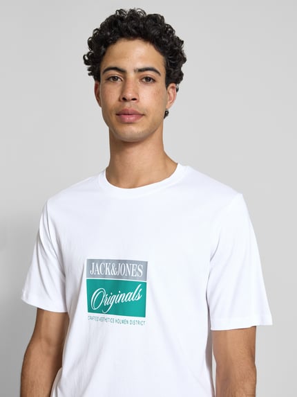 Mężczyznamodel nosi T-Shirt z nadrukiem statement model 'RHYERES' od Jack & Jones, biała, czysta woskowana bawełna, krój regular fit, okrągły dekolt, długość pleców w rozmiarze M: 67 cm, widok na górną część ciała od przodu.