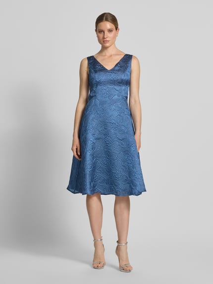 Vrouwenmodel draagt cocktailjurk met structuurpatroon en V-hals van Vera Mont, dames, model in A-lijn, midi-jurk, ganzichtsvooraanzicht.