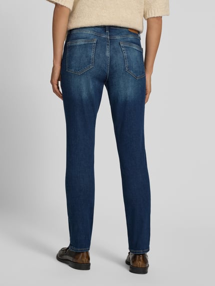 Frauenmodel trägt Slim Fit Jeans aus Baumwoll-Mix Modell 'BETSY SLIM' von s.Oliver RED LABEL, blaue Waschung, Ganzkörperansicht Rückansicht. Damen Skinny Fit Jeans von s.Oliver RED LABEL.