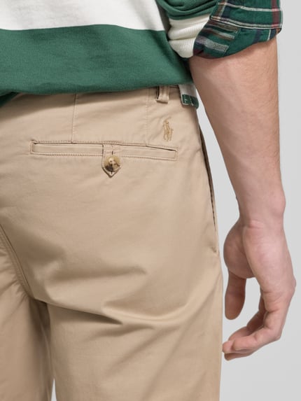 Männermodel trägt stoffen broek met steekzakken en achterzakken van Polo Ralph Lauren, Mix van katoen en elastaan, slim fit, detailaufnahme achterzijde.