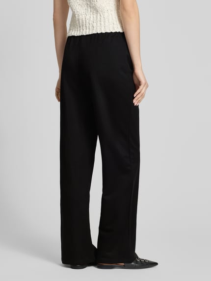Frauenmodel trägt Loose Fit Weite Hose aus Viskose-Mix Modell 'JANY' von Only, Optik: Unifarben, Bundabschluss: elastisch mit Tunnelzug, Ganzkörperansicht Rückansicht.