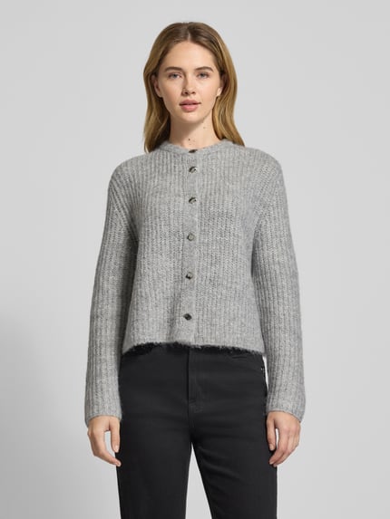 Frauenmodel trägt Strickjacke mit Rundhalsausschnitt Modell 'TIAH' von Someday aus Material-Mix mit Woll-Anteil, Regular-Fit, Knopfleiste, Nahaufnahme Oberkörper.