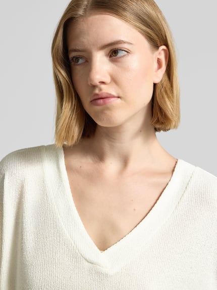 Frauenmodel trägt Strickshirt mit V-Ausschnitt Modell 'Delia' von Soyaconcept, Viskose-Mix mit Stretch-Anteil, Relaxed-Fit, Nahaufnahme Oberkörper.