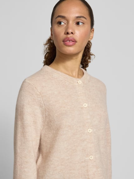 Vrouwenmodel draagt Regular Fit Strickjacke aus Woll-Mix mit Alpaka-Anteil Modell 'LULU NEW' van Selected Femme, look: effen, knitwear van wolmix met geribde mouwboord en rompzoom, knoopsluiting, o-neck, lange mouw, materiaalverwerking: knitwear, kleur lichtbeige, nahaufnahme bovenlichaam.
