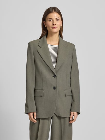 Frauenmodel trägt Relaxed Fit Blazer mit Viskose-Anteil Modell 'Napoli' von Mango in Oliv, Doppelknopfleiste, Reverskragen, Ganzkörperansicht von vorne.