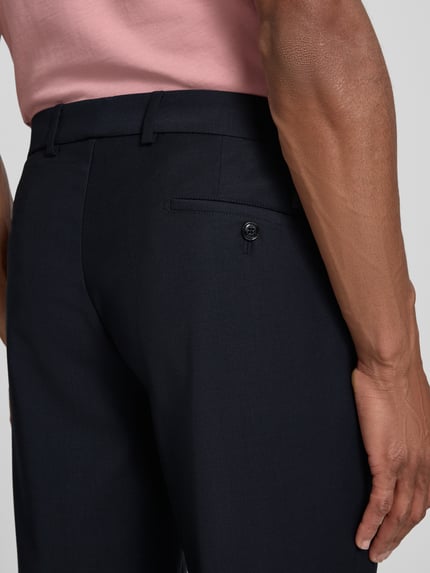 Männermodel trägt schwarze Straight Fit Hose mit Lanawoll-Anteil Modell 'Sake' von JOOP! COLLECTION, Detailaufnahme Rückansicht, Elastischer-Material-Mix, Tunnelzug, Bundweite 44 cm, Innenbeinlänge 80 cm bei Größe 50.