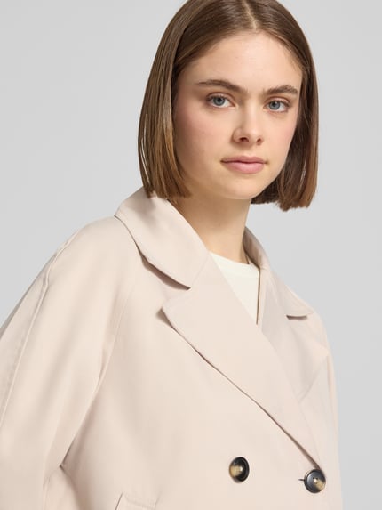 Vrouwenmodel draagt Regular Fit Trenchcoat met brede reverskraag model 'SCARLETT' van Pieces, look: effen, korte lengte, dubbele knoopsluiting, lange mouw, zij-steekzakken, Nahaufnahme Oberkörper.