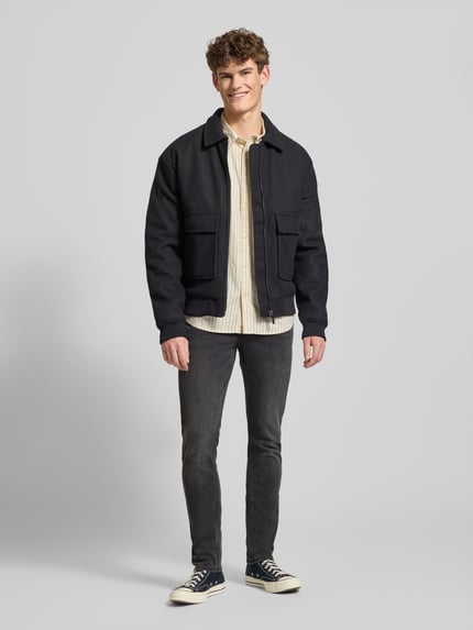 Männermodel trägt Stone Washed Slim Fit Jeans von ONLY & SONS in dunklem Grau, Baumwollmischung mit Stretch-Anteil, Ganzkörperansicht von vorne.