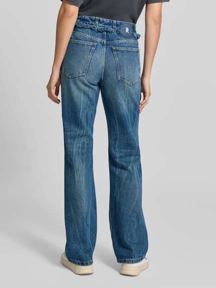 Frauenmodel trägt Regular Fit Bootcut-Jeans mit Paperbag-Bund von Rabanne in Medium Wash Denim, Used Look, sichtbare Nähte und 5-Pocket-Design, Ganzkörperansicht Rückansicht.