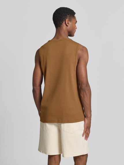 Männermodel trägt Slim Fit Tank Top aus Baumwoll-Mix von s.Oliver RED LABEL in Braun, unifarben, breite Träger, Feinripptextur, Ganzkörperansicht Rückansicht.
