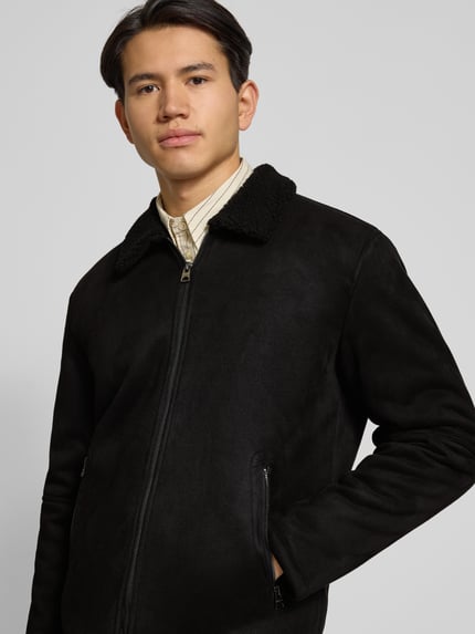 Männermodel trägt Regular Fit Bomberjacke mit Kunstfellkragen Modell 'ROYCE' von Only & Sons in Wildleder-Optik, Nahaufnahme Oberkörper.