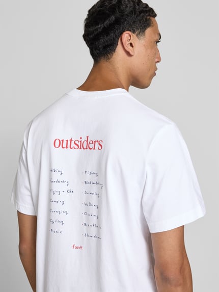 Männermodel trägt Regular Fit T-Shirt mit Statement-Print von Forét aus bawełna, okrągły dekolt, krótki rękaw, długość tyłu 67 cm, Ganzkörperansicht Rückansicht.