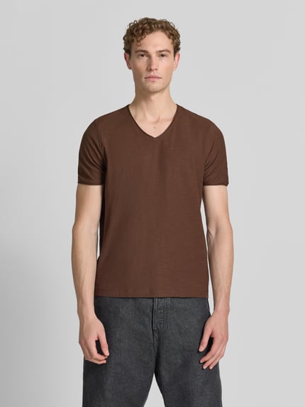 Męski model nosi T-Shirt mit V-Ausschnitt und Rollsaum von MCNEAL z bawełny, krój regular fit, brązowy, długość tyłu w rozmiarze M: 81 cm, całkowity widok z przodu