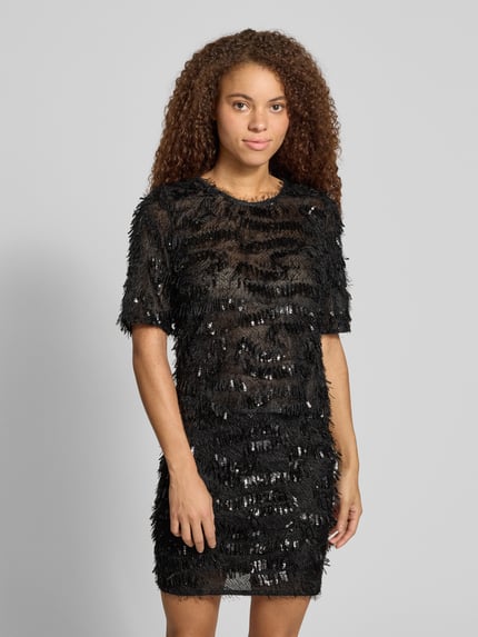 Frauenmodel trägt Cropped Blusentop mit Paillettenfransen von PIECES in Schwarz mit strukturierter Optik und Rundhals, Nahaufnahme Oberkörper.