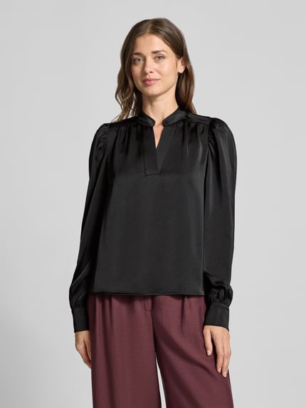 Vrouwenmodel draagt Langarmbluse met Stretch-Anteil Modell 'Rosslyn' van Neo Noir in zwart satijn met V-hals en ballonmouwen, ontspannen fit, licht glanzende textuur, schoudernaden met plooien, vooraanzicht bustenauaufnahme.