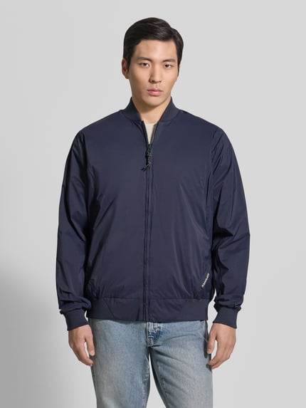 Męski model nosi bluzon z prostym krojem, stójką, zamek błyskawiczny, detal z logo, prążkowane wykończenia, GOFRANCK Blouson mit Label-Detail Modell 'MILD', długość tyłu w rozmiarze M: 70 cm, szerokość ramion w rozmiarze M: 45 cm, szerokość klatki piersiowej w rozmiarze M: 63 cm, długość rękawów w rozmiarze M: 71 cm, kolor granatowy, gładka tekstura, Ganzkörperansicht von vorne