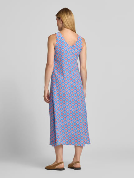 Frauenmodel trägt Midikleid aus Viskose mit V-Ausschnitt von Smith and Soul im Allover-Look, A-Linie, blaue und rote Muster, Ganzkörperansicht Rückansicht.