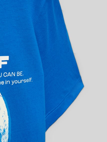 Mädchen trägt Regular Fit T-Shirt aus reiner Baumwolle von s.Oliver RED LABEL, Optik: Unifarben, Motiv-Print, Nahaufnahme Oberkörper.