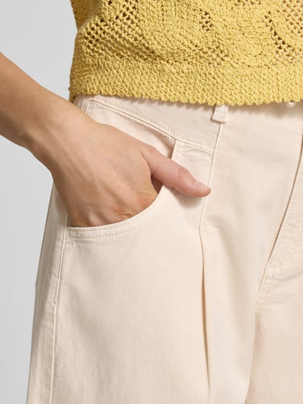 Frauenmodel trägt Barrel Fit Jeans aus Baumwoll-Mix von s.Oliver RED LABEL in Unifarbe mit seitlichen Eingrifftaschen, Nahaufnahme Oberschenkel.