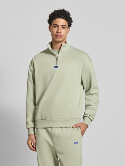 Männermodel trägt Regular Fit Troyer aus reiner Baumwolle Modell 'NEELER' von Hugo Blue in unifarben hellem Mint, Ganzkörperansicht von vorne.