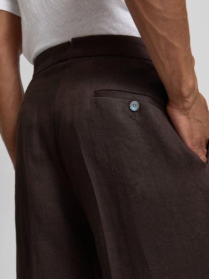 Männermodel trägt Relaxed Fit Leinenhose aus reinem Leinen Modell 'PERINO' von BOSS, Optik: Unifarben, Materialverarbeitung: Twill, Nahaufnahme Rückansicht.