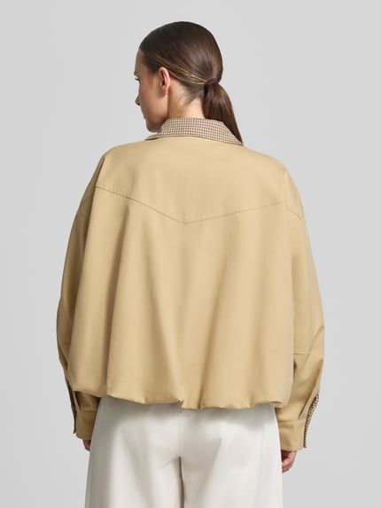 Männermodel trägt Relaxed Fit Jacke mit Lyocell-Anteil von Rich & Royal, mieszanka bawełny i lyocellu, krój relaxed fit, stójka, zamek błyskawiczny, plisa na całej długości, Długość tyłu w rozmiarze 36: 58 cm, Szerokość ramion w rozmiarze 36: 60 cm, Szerokość klatki piersiowej w rozmiarze 36: 67 cm, Długość rękawów w rozmiarze 36: 54 cm, jasny beż, geometryczne linie, gładka tekstura, Ganzkörperansicht Rückansicht.