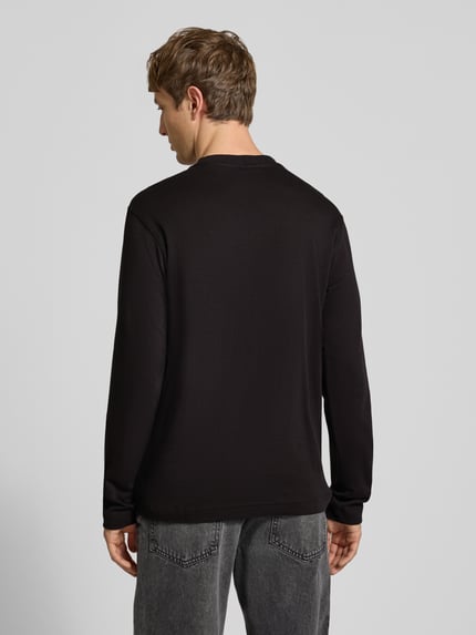 Männermodel trägt Langarmshirt mit Logo-Schriftzug von G-Star RAW, unifarben, Regular Fit, strukturierte Jersey-Optik, Ganzkörperansicht Rückansicht.