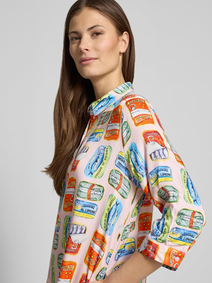 Modelka nosi 'Knielanges Hemdblusenkleid aus Viskose im Allover-Look' od Milano Italy, kolorowy wzór, czysta wiskoza, proste cięcie, zbliżenie na górną część ciała.