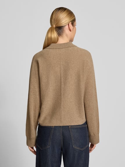 Frauenmodel trägt Regular Fit Strickjacke aus reiner Wolle Modell 'Dulena' von OPUS in Beige, strukturierte Oberfläche, Damen Pullover, Ganzkörperansicht Rückansicht.