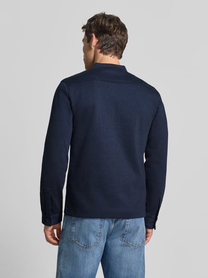 Męski model nosi Slim Fit Sweatjacke mit Stehkragen von Lindbergh, granatowa Mieszanka materiałów z dodatkiem streczu, wpuszczane kieszenie, krój slim fit, zamek błyskawiczny, Długość tyłu w rozmiarze M: 67 cm, Długość rękawów w rozmiarze M: 66 cm, Ganzkörperansicht Rückansicht.