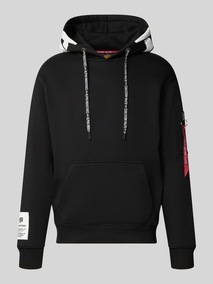 Produktfoto, Regular Fit Hoodie aus Baumwoll-Mix mit Label-Patch von Alpha Industries, schwarze Kapuze, Känguru-Tasche, Ärmel-Tasche, weißer Print, Struktur glatt