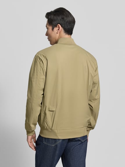 Męski model nosi Blouson mit Label-Detail Modell 'MILD' od GOFRANCK, beżowy kolor, prosty krój, stebnowane faktury, widok całopostaciowy z tyłu, długość tyłu 70 cm, szerokość w rozmiarze M 63 cm, szerokość ramion w rozmiarze M 45 cm, długość rękawa 71 cm.