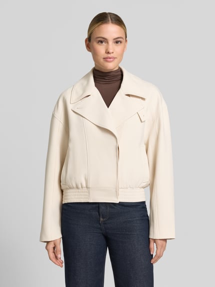 Frauenmodel trägt Regular Fit Jacke mit Viskose-Anteil Modell 'Najoma' von someday, cremefarben, Reverskragen, elastischer Bund, glatte Textur, Ganzkörperansicht von vorne.