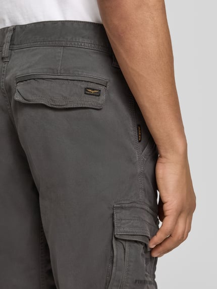 Männermodel trägt Bermudas mit Pattentaschen und Label-Stitchings von PME Legend in Grau, seitliche Eingrifftaschen, Nahaufnahme Rückansicht. Bundweite 41 cm, Innenbeinlänge 26 cm, Motiv- und Label-Stitchings, Klettverschluss.