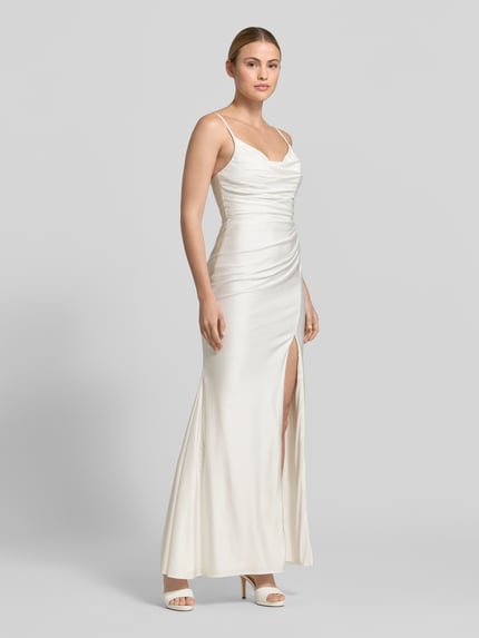 Frauenmodel trägt Abendkleid mit seitlichem Gehschlitz und Spaghettiträgern von Hey Kyla, cremefarben, Baumwoll-Mix mit Stretch-Anteil, Körpernaher-Schnitt, Maxikleid, V-Ausschnitt, Raffungen, Haken-Reißverschluss, Ganzkörperansicht von vorne.