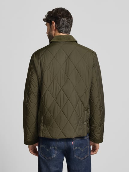 Männermodel trägt olivgrüne Steppjacke mit Umlegekragen aus Cord Modell 'BENJA' von Casual Friday, Rautensteppung, Ganzkörperansicht Rückansicht.