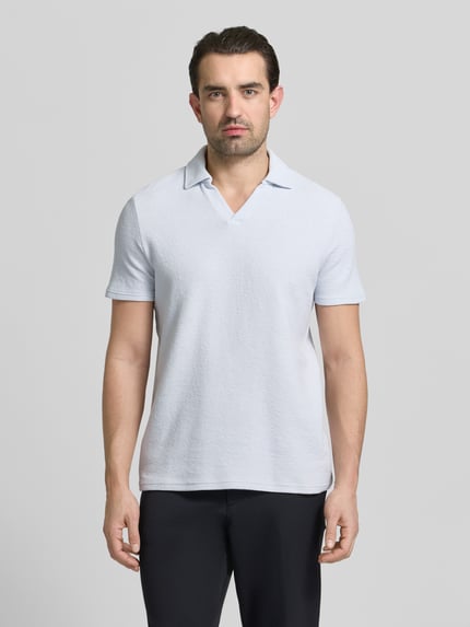 Männermodel trägt Regular Fit Poloshirt aus Baumwoll-Mix von MCNEAL in Hellgrau, Waffle-Piqueé, Umlegekragen, Ganzkörperansicht von vorne.