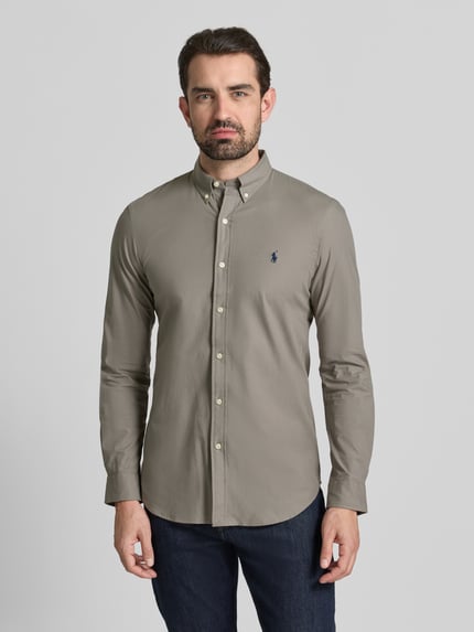 Männermodel trägt Freizeithemd mit Label-Stitching von Polo Ralph Lauren, olivfarben, Regular Fit, Baumwoll-Elasthan-Mix, Ganzkörperansicht von vorne.
